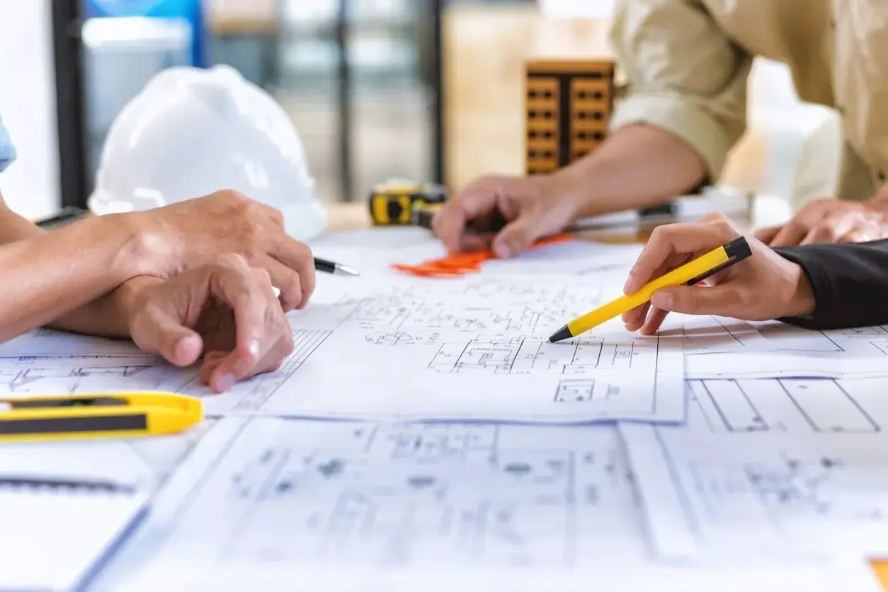 A DSC designer marking up construction blueprints by hand.